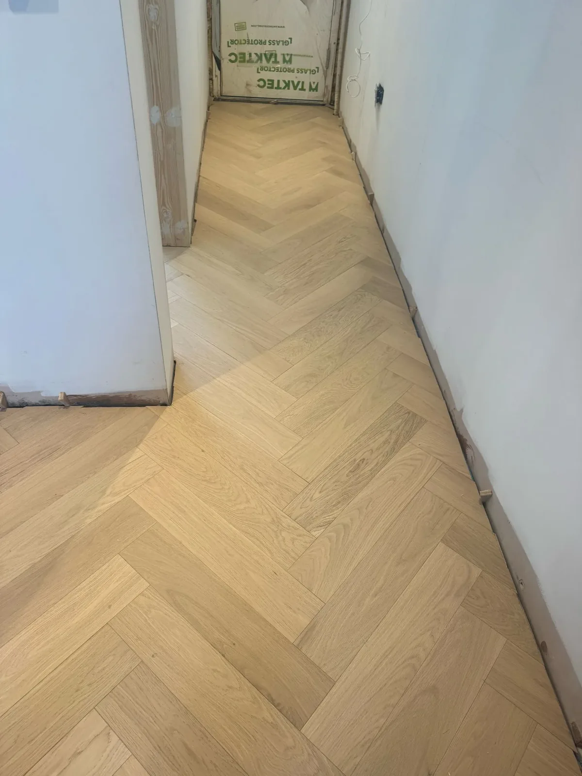 White-oiled engineered oak herringbone flooring fitted by LIGNORA in a client hallway
